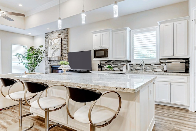 321 Twin Timbers Ln, Kemah, TX 77565 - kitchen featuring black microwave, a center island, decorative backsplash, white cabinetry, and recessed lighting