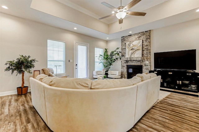 321 Twin Timbers Ln, Kemah, TX 77565 - living area with wood finished floors, a fireplace, a ceiling fan, a raised ceiling, and recessed lighting