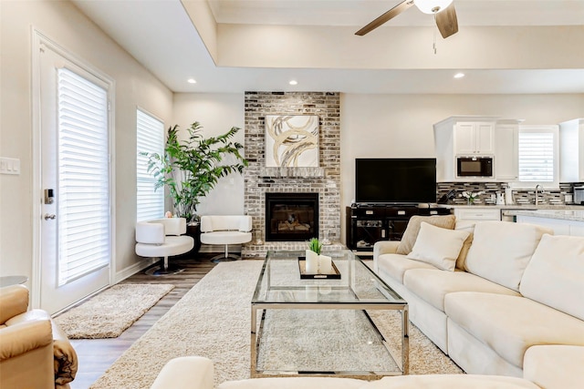 321 Twin Timbers Ln, Kemah, TX 77565 - living area with a ceiling fan, wood finished floors, recessed lighting, a brick fireplace, and baseboards
