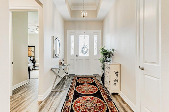 321 Twin Timbers Ln, Kemah, TX 77565 - entryway featuring light wood-style floors, ornamental molding, a raised ceiling, baseboards, and ceiling fan