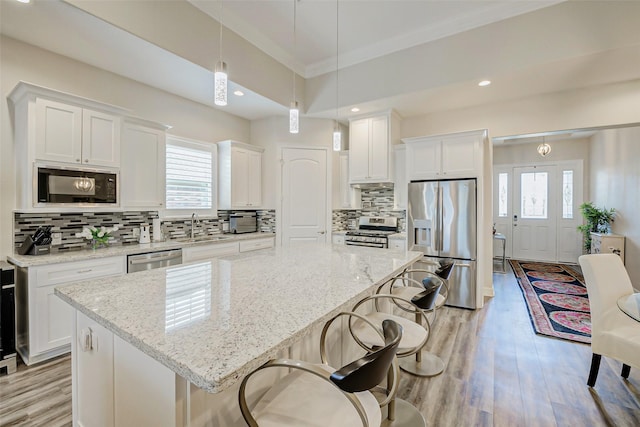 321 Twin Timbers Ln, Kemah, TX 77565 - kitchen featuring stainless steel appliances, plenty of natural light, white cabinetry, a kitchen island, and recessed lighting