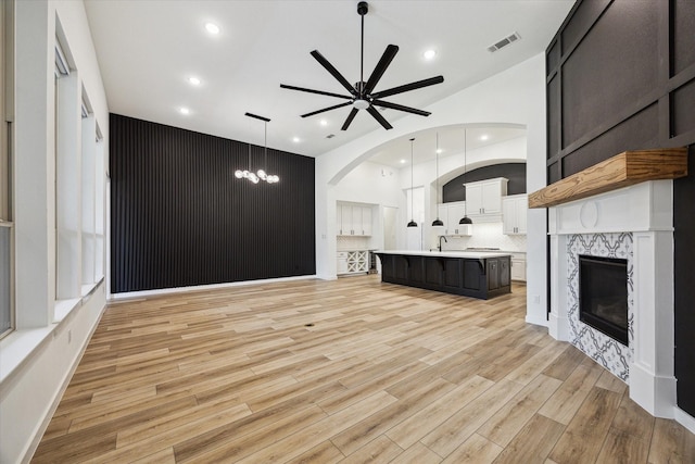 23910 Birchwood Lake Ln, Katy, TX 77493 - unfurnished living room featuring a ceiling fan, recessed lighting, light wood finished floors, a fireplace, and arched walkways