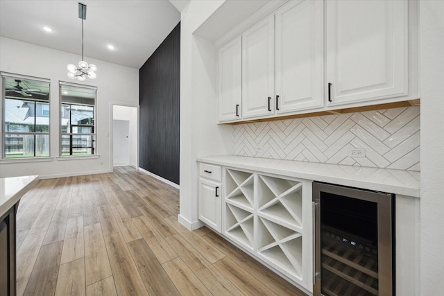 23910 Birchwood Lake Ln, Katy, TX 77493 - bar area featuring beverage cooler, tasteful backsplash, light wood finished floors, a chandelier, and baseboards