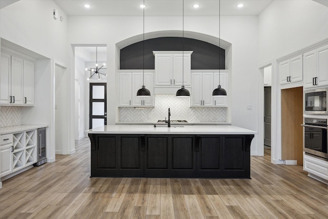 23910 Birchwood Lake Ln, Katy, TX 77493 - kitchen with oven, built in microwave, tasteful backsplash, beverage cooler, and light countertops