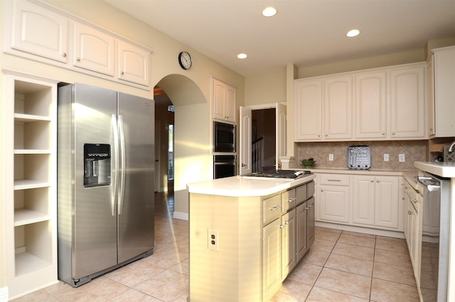 22503 Rippling Shore Ct, Katy, TX 77494 - kitchen with appliances with stainless steel finishes, arched walkways, a center island, light tile patterned floors, and recessed lighting