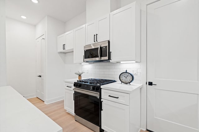 3848 Seabrook St, Houston, TX 77021 - kitchen featuring stainless steel microwave, range with gas cooktop, light countertops, light wood finished floors, and recessed lighting