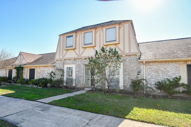 12251 Sharpview Dr, Houston, TX 77072 - tudor-style house with a front yard, a shingled roof, stone siding, and brick siding