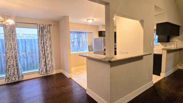 2014 Lexington Woods Dr, Spring, TX 77373 - kitchen featuring stainless steel fridge, light stone countertops, wood finished floors, and baseboards