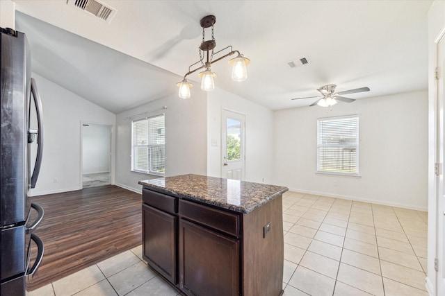 5002 Manor Stone Ln, Rosenberg, TX 77469 - kitchen with freestanding refrigerator, light tile patterned flooring, plenty of natural light, ceiling fan, and vaulted ceiling