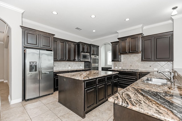 27415 Ashford Sky Ln, Katy, TX 77494 - kitchen featuring stainless steel appliances, arched walkways, light stone counters, a center island, and recessed lighting