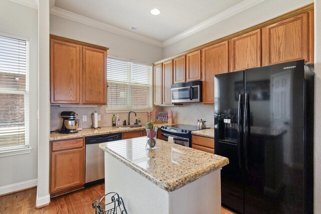 620 Cathedral Sq, Beaumont, TX 77701 - kitchen featuring stainless steel appliances, a sink, light wood-style flooring, tasteful backsplash, and ornamental molding
