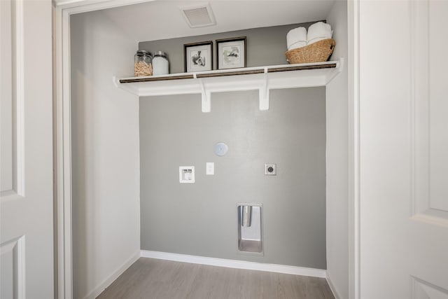 3025 Wild Dunes Dr, Katy, TX 77493 - washroom featuring gas dryer hookup, electric dryer hookup, light wood-style flooring, and baseboards