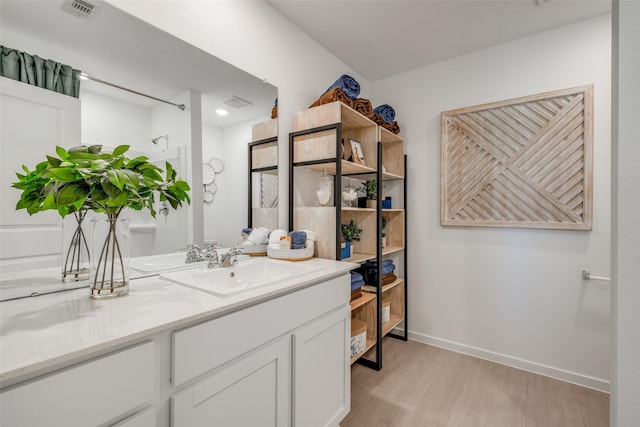 3025 Wild Dunes Dr, Katy, TX 77493 - bathroom with wood finished floors, vanity, and baseboards