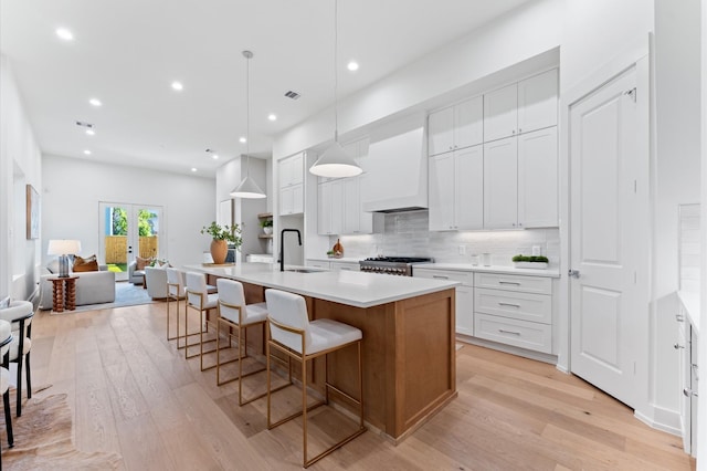 322 Aurora St, Houston, TX 77008 - kitchen with premium range hood, a sink, open floor plan, stove, and light wood finished floors