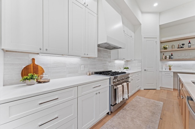 322 Aurora St, Houston, TX 77008 - kitchen with appliances with stainless steel finishes, light wood-style flooring, custom range hood, light countertops, and white cabinetry
