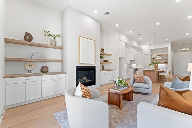 322 Aurora St, Houston, TX 77008 - living room with light wood-type flooring, a glass covered fireplace, and recessed lighting