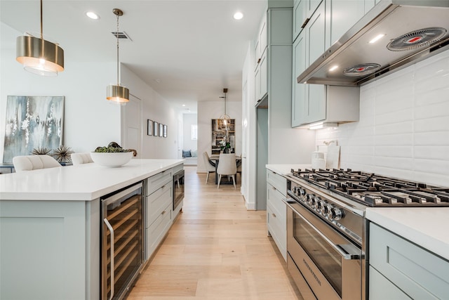 2015 Hopkins St, Houston, TX 77006 - kitchen with stainless steel appliances, beverage cooler, under cabinet range hood, light countertops, and recessed lighting