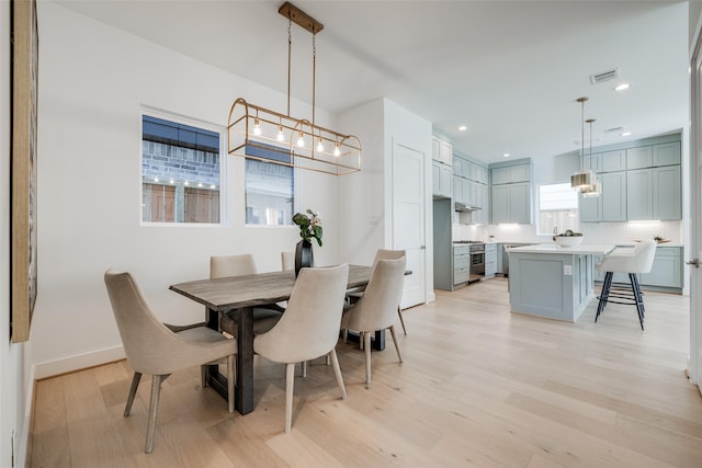 2015 Hopkins St, Houston, TX 77006 - dining space with light wood-type flooring, recessed lighting, healthy amount of natural light, baseboards, and a chandelier