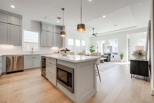 2015 Hopkins St, Houston, TX 77006 - kitchen with dishwasher, gray cabinets, built in microwave, beverage cooler, and tasteful backsplash