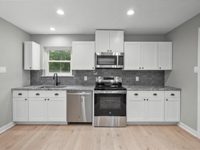 3422 N Elm Rd, Santa Fe, TX 77517 - kitchen with stainless steel appliances, a sink, light wood-type flooring, baseboards, and recessed lighting