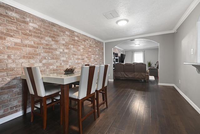 7162 Crownwest St Unit 7162, Houston, TX 77072 - dining space featuring arched walkways, baseboards, a textured ceiling, dark wood-style floors, and brick wall
