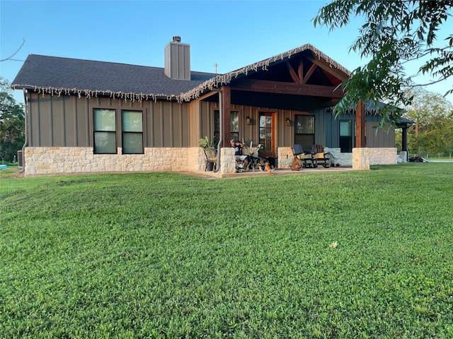 3295 Fm 524, Sweeny, TX 77480 - back of property with board and batten siding, stone siding, a chimney, and a yard