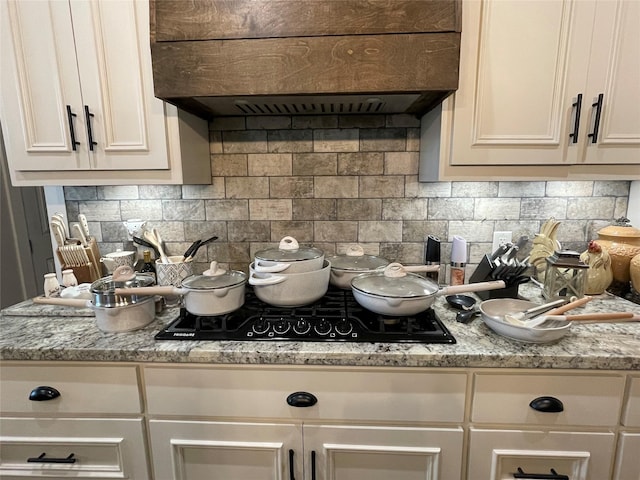 3295 Fm 524, Sweeny, TX 77480 - kitchen view of range hood, black gas cooktop, tasteful backsplash, and white cabinetry