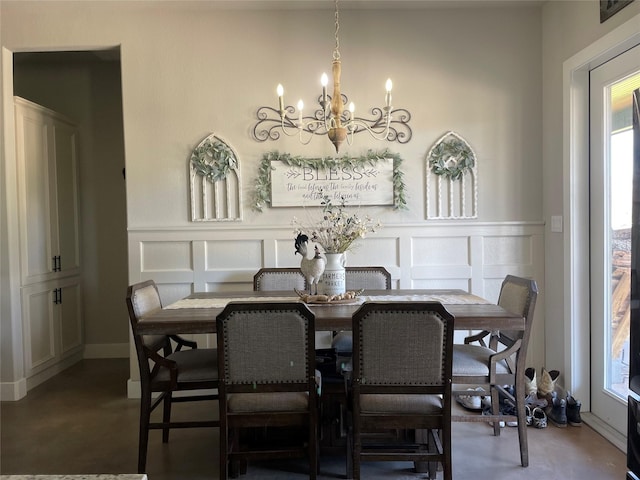 3295 Fm 524, Sweeny, TX 77480 - dining space featuring a chandelier, a decorative wall, concrete flooring, and a wainscoted wall