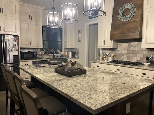 3295 Fm 524, Sweeny, TX 77480 - kitchen with black appliances, a chandelier, premium range hood, a kitchen island, and decorative backsplash
