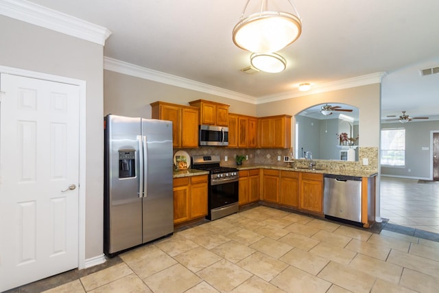 1802 Dominic Ln, Houston, TX 77049 - kitchen featuring appliances with stainless steel finishes, ceiling fan, a sink, brown cabinets, and ornamental molding
