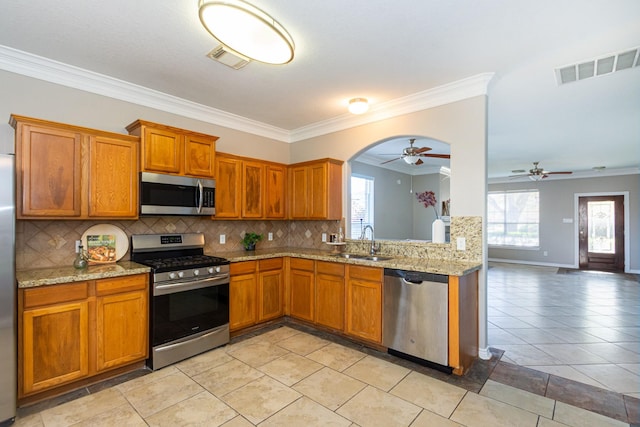 1802 Dominic Ln, Houston, TX 77049 - kitchen featuring stainless steel appliances, a sink, ceiling fan, plenty of natural light, and ornamental molding