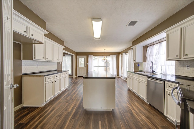1322 Village Garden Dr, Missouri City, TX 77459 - kitchen with dishwasher, dark countertops, range, a chandelier, and a textured ceiling