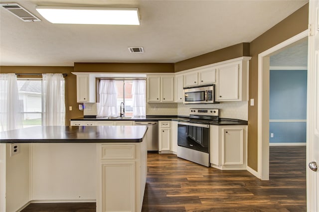 1322 Village Garden Dr, Missouri City, TX 77459 - kitchen with stainless steel appliances, dark countertops, dark wood-style floors, and a kitchen island
