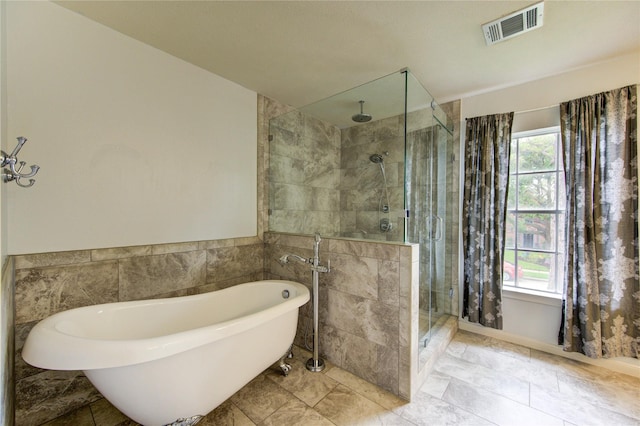 1322 Village Garden Dr, Missouri City, TX 77459 - bathroom with a shower stall, a soaking tub, tile walls, and wainscoting