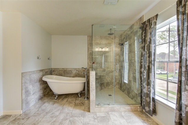 1322 Village Garden Dr, Missouri City, TX 77459 - bathroom with healthy amount of natural light, a stall shower, a soaking tub, tile walls, and wainscoting