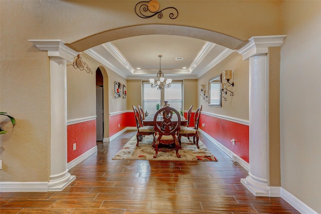 8215 Frontenac Dr, Houston, TX 77071 - dining room with arched walkways, a tray ceiling, crown molding, wood finished floors, and decorative columns