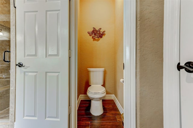 8215 Frontenac Dr, Houston, TX 77071 - full bathroom featuring toilet, a textured wall, a tile shower, and wood finished floors