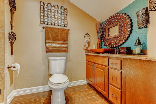 8215 Frontenac Dr, Houston, TX 77071 - half bath with toilet, wood tiled floors, vanity, baseboards, and lofted ceiling