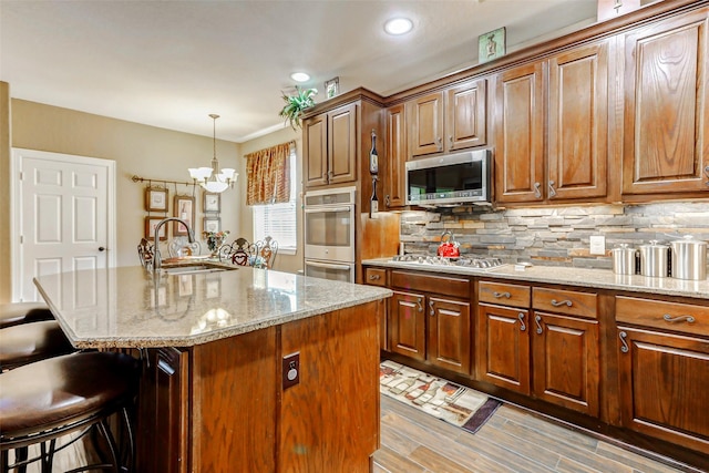 8215 Frontenac Dr, Houston, TX 77071 - kitchen featuring stainless steel appliances, a sink, a breakfast bar, light stone countertops, and recessed lighting