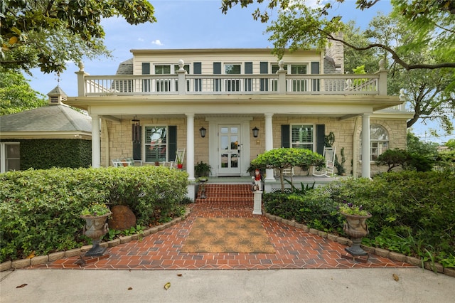 916 E James St, Baytown, TX 77520 - view of front of house featuring a balcony, covered porch, and stone siding
