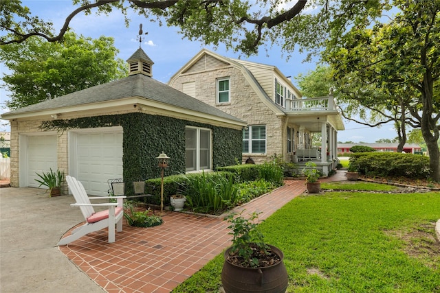 916 E James St, Baytown, TX 77520 - view of front of house with driveway, stone siding, a front yard, and a balcony