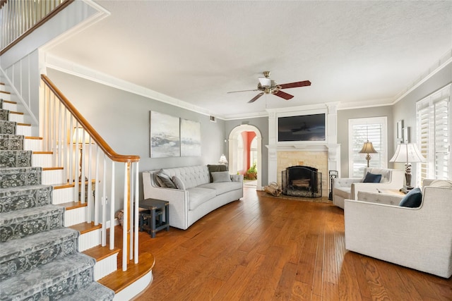 916 E James St, Baytown, TX 77520 - living room featuring a ceiling fan, crown molding, stairs, wood-type flooring, and a fireplace