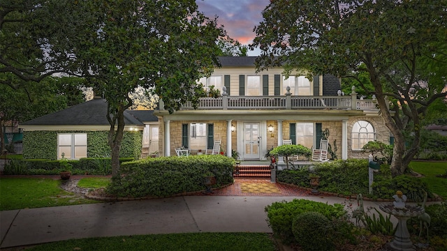 916 E James St, Baytown, TX 77520 - view of front of house featuring covered porch, a balcony, and stone siding