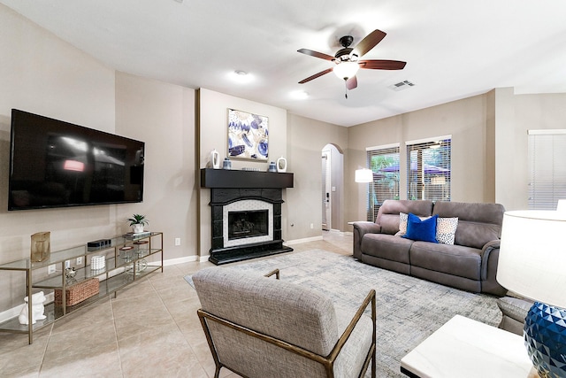 28515 Blue Holly Ln, Katy, TX 77494 - living area featuring arched walkways, ceiling fan, baseboards, a fireplace with raised hearth, and tile patterned floors