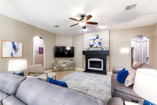 28515 Blue Holly Ln, Katy, TX 77494 - living area with arched walkways, a ceiling fan, baseboards, and a fireplace with raised hearth