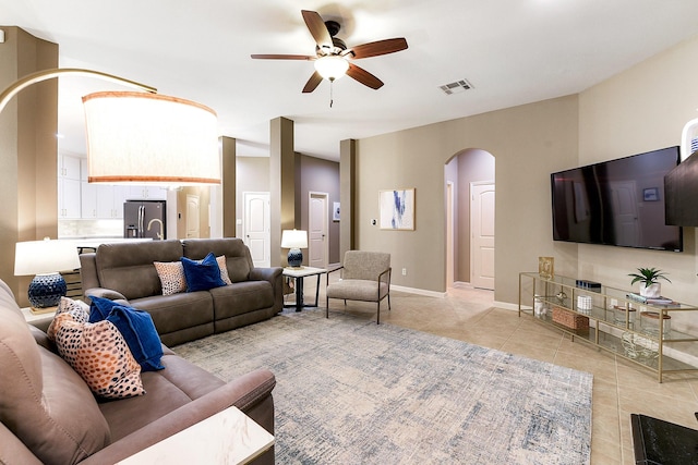28515 Blue Holly Ln, Katy, TX 77494 - living room with arched walkways, light tile patterned floors, ceiling fan, and baseboards