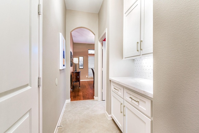 28515 Blue Holly Ln, Katy, TX 77494 - hallway featuring arched walkways, light tile patterned floors, and baseboards