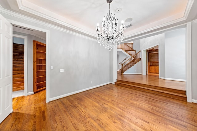 2042 Darby Ln, Fresno, TX 77545 - unfurnished dining area with a tray ceiling, a chandelier, stairs, light wood-style flooring, and ornamental molding