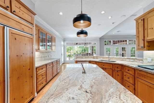 2042 Darby Ln, Fresno, TX 77545 - kitchen with a sink, light wood-style floors, tasteful backsplash, glass insert cabinets, and recessed lighting