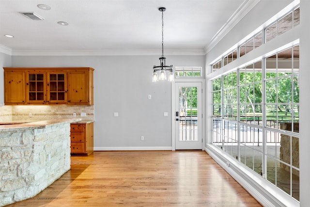 2042 Darby Ln, Fresno, TX 77545 - kitchen with brown cabinetry, a chandelier, light wood-type flooring, hanging light fixtures, and ornamental molding